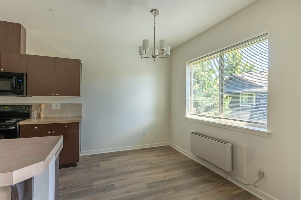A kitchen with brown cabinets and a microwave at Stoneplace Apartment Homes, Molalla, Oregon