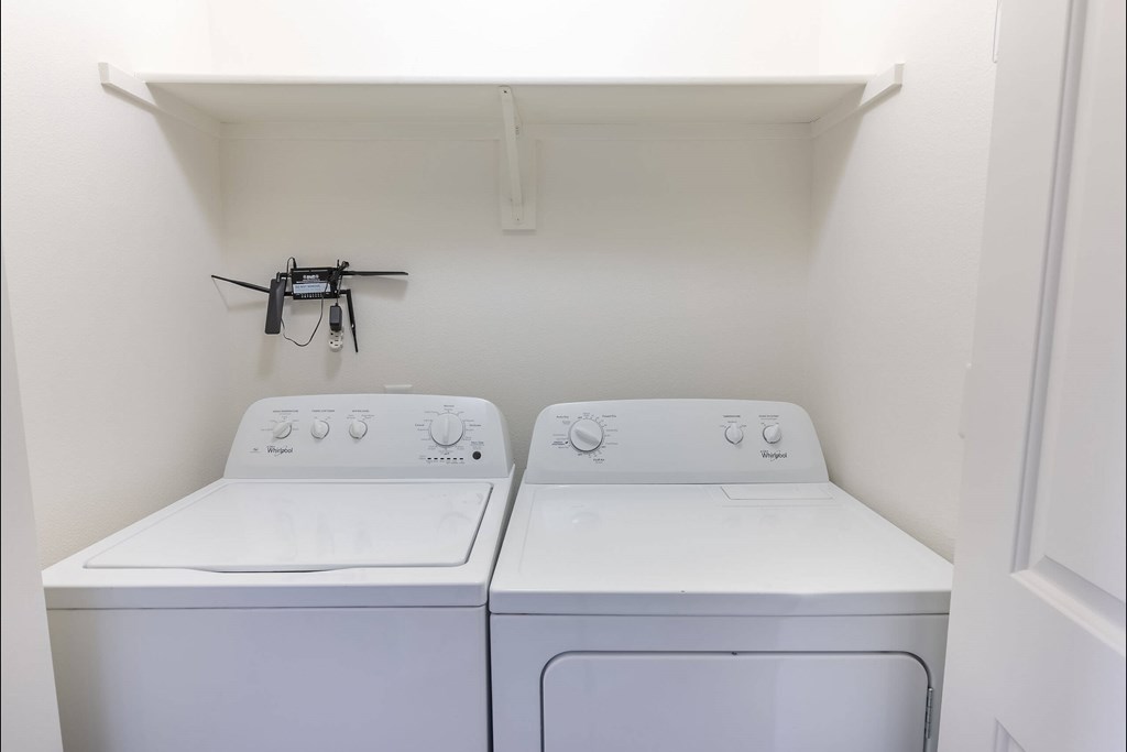 Two white washing machines in a small laundry room at Stoneplace Apartment Homes, Oregon, 97038