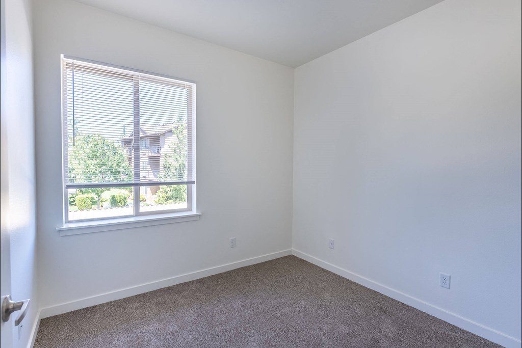 A room with a window and a carpeted floor at Stoneplace Apartment Homes, Oregon, 97038