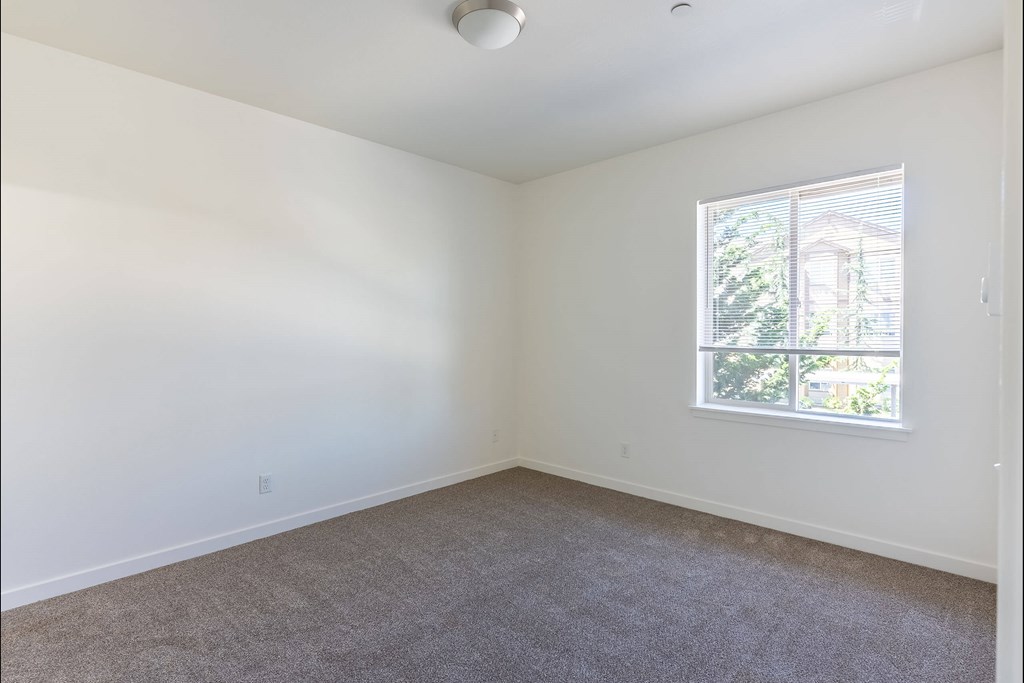 A room with a carpeted floor and a window at Stoneplace Apartment Homes, Oregon
