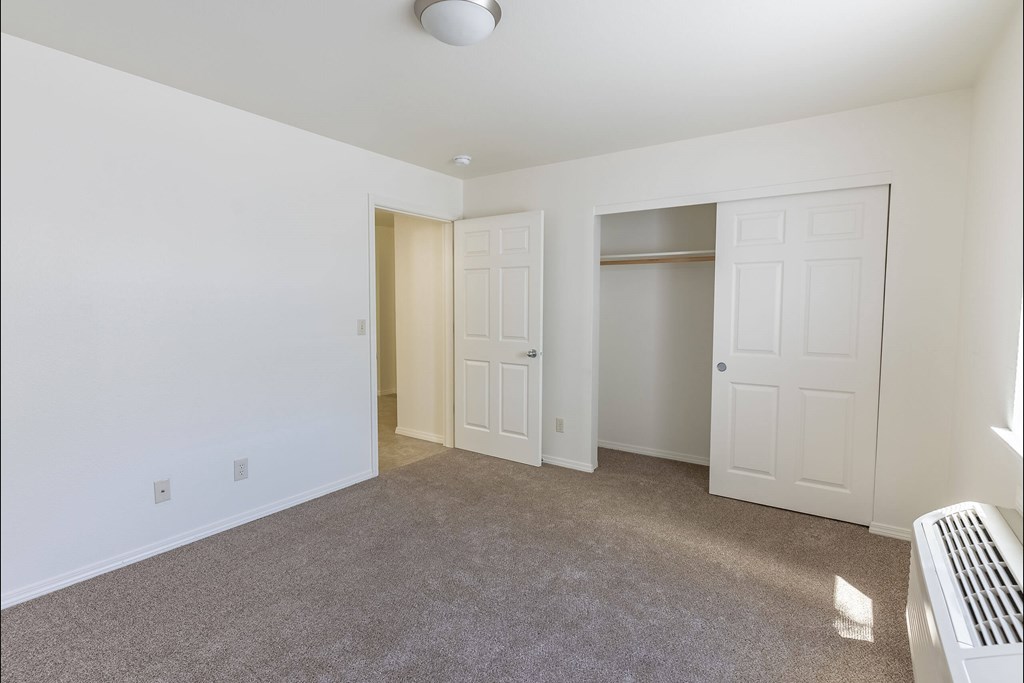 A room with a carpeted floor and a heater on the wall at Stoneplace Apartment Homes, Molalla, OR