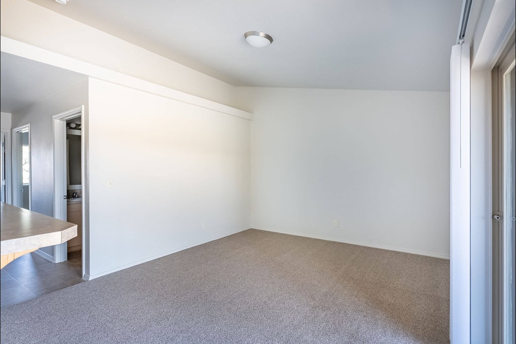 A large, empty room with a carpeted floor and white walls at Stoneplace Apartment Homes, Molalla, 97038