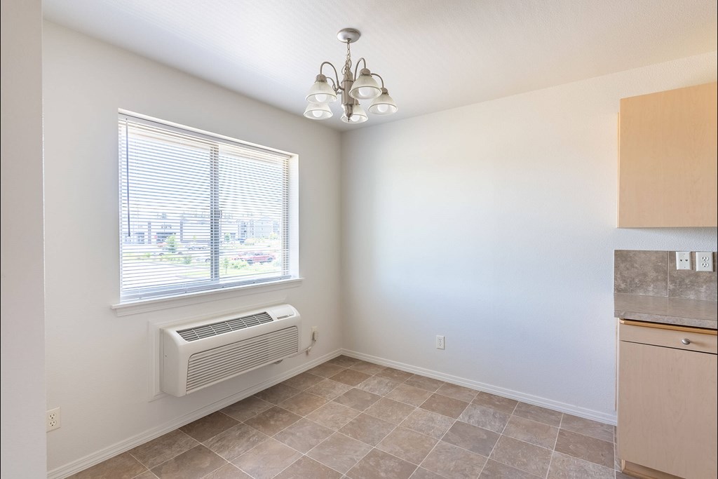 A room with a window, tiled floor, and a chandelier at Stoneplace Apartment Homes, Molalla, Oregon