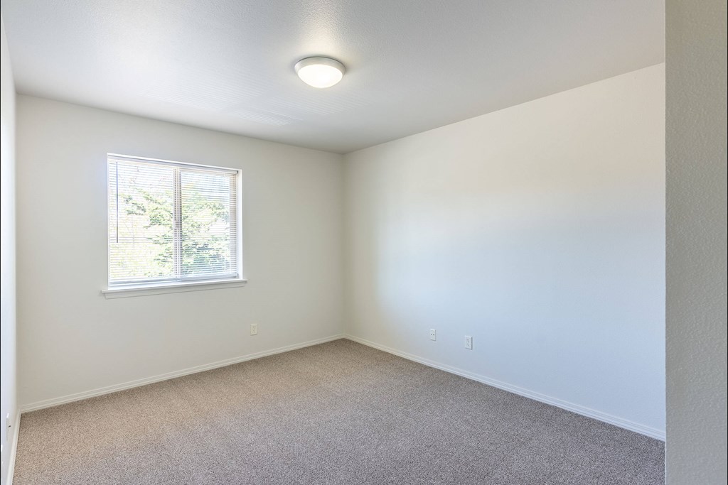 A room with a window and carpeted floor at Stoneplace Apartment Homes, Molalla, OR