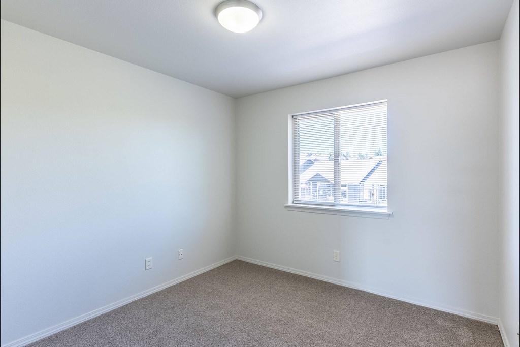 A room with a window and carpeted floor at Stoneplace Apartment Homes, Molalla, 97038