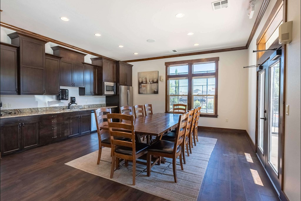 A kitchen with dark wood cabinets and a dining table with chairs. A kitchen with dark wood cabinets and a dining table with chairs at Stoneplace Apartment Homes, Molalla