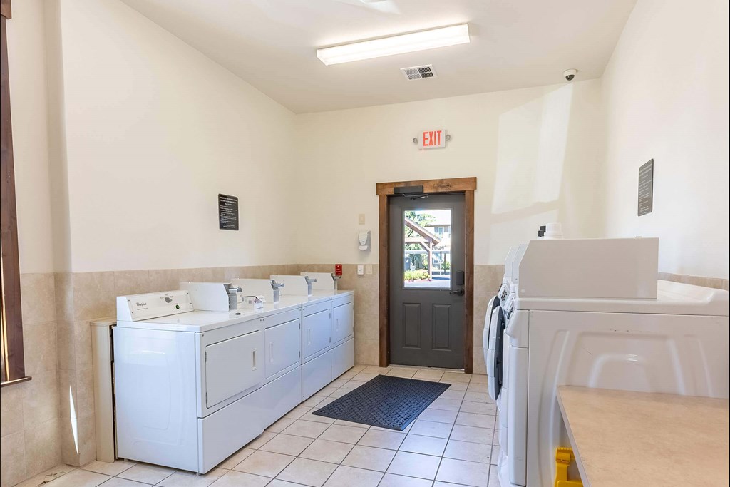 A bathroom with a row of sinks and a door at Stoneplace Apartment Homes, Oregon, 97038