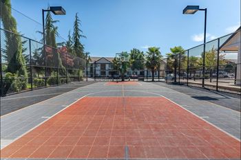 A tennis court with a net and a building in the background.