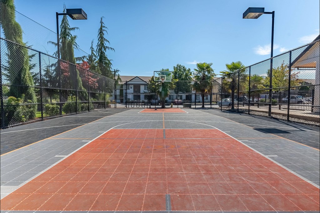 A tennis court with a net and a building in the background. A tennis court with a net and a building in the background at Stoneplace Apartment Homes, Molalla, 97038