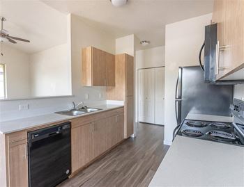 A kitchen with a black dishwasher and stove top.