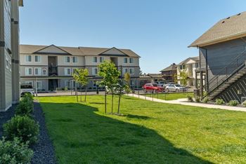 A sunny day at a residential area with apartment buildings and green lawns.