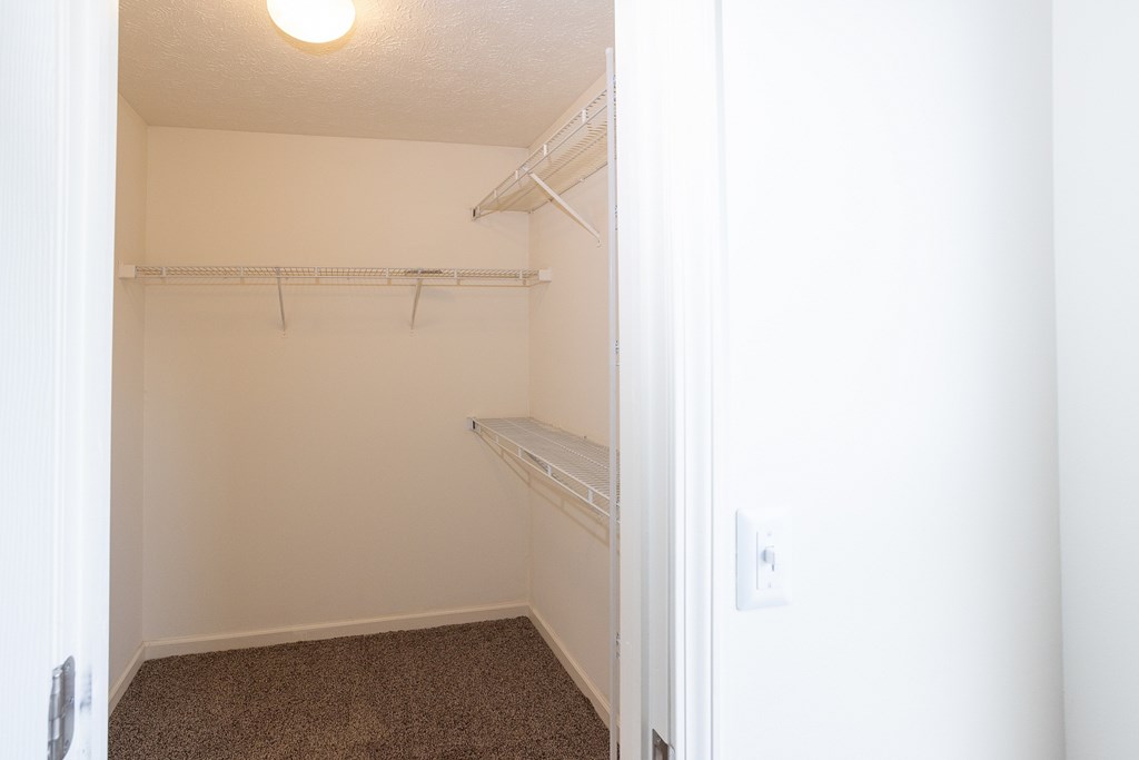 A small, empty room with a carpeted floor and white walls.