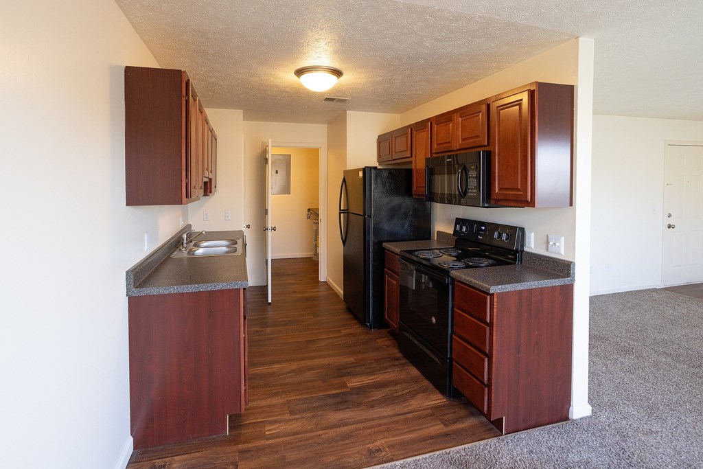 A kitchen with dark wood cabinets and appliances.