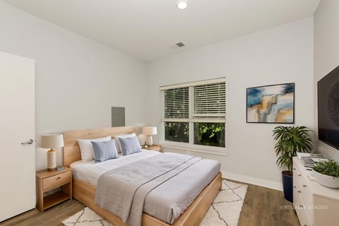 A bedroom with a large bed and a painting on the wall.