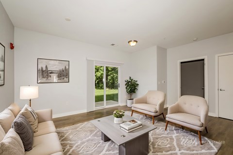 A living room with a white couch, a coffee table, and a potted plant.