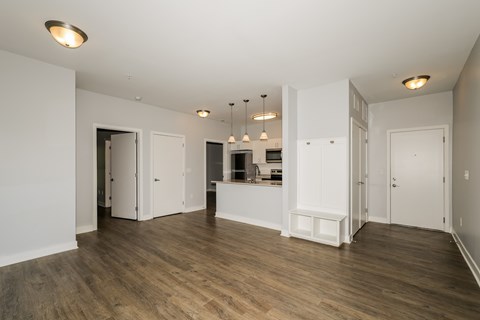 A spacious room with wooden floors and white walls.
