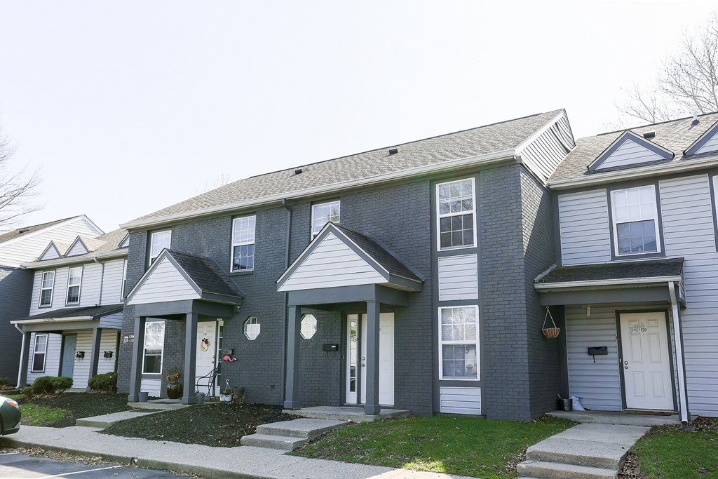 A grey two story house with a white door and windows.