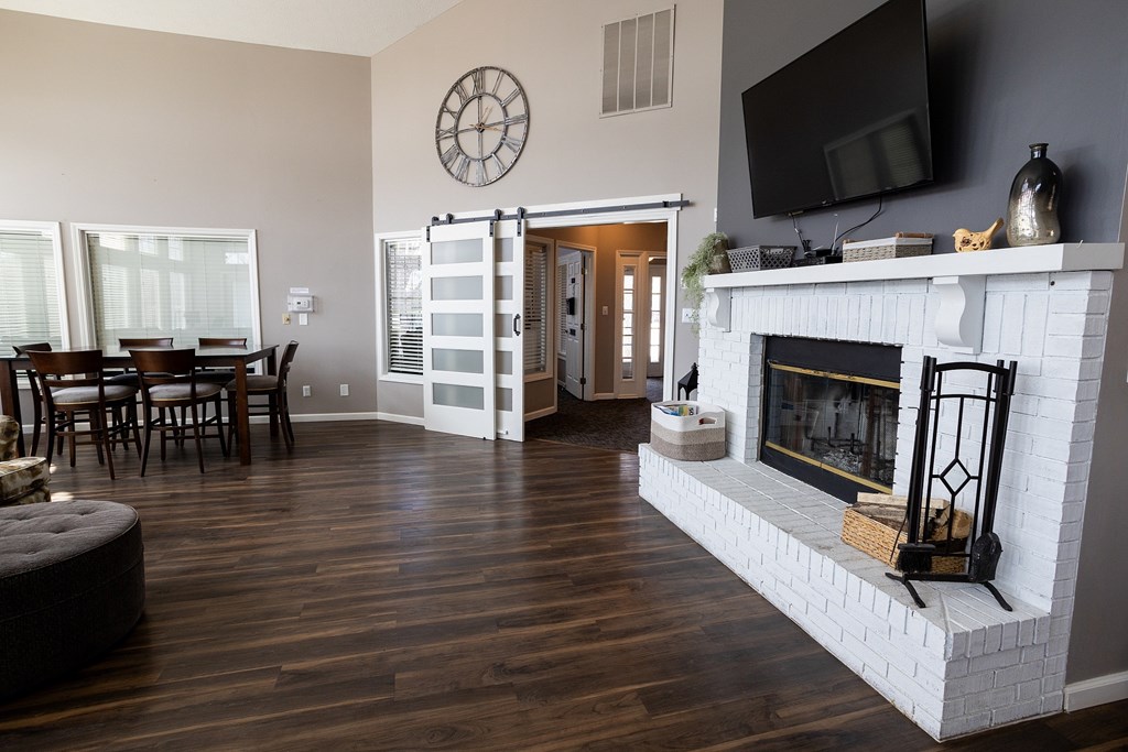 A living room with a fireplace and a television mounted on the wall.