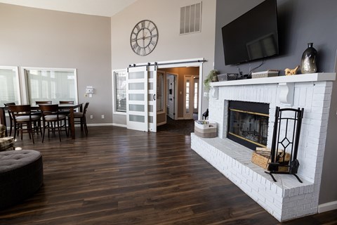 A living room with a fireplace and a television mounted on the wall.