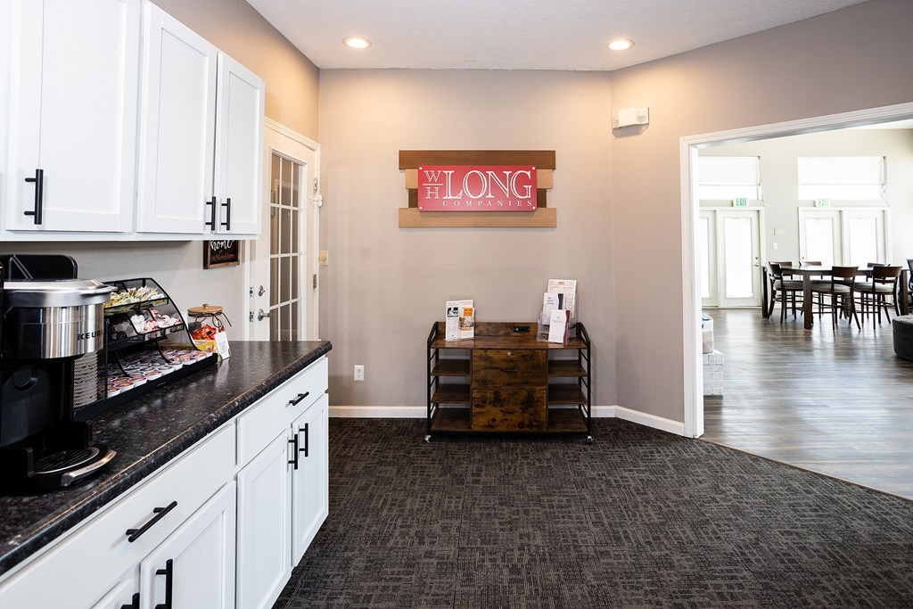 A kitchen with a black counter top and white cabinets.