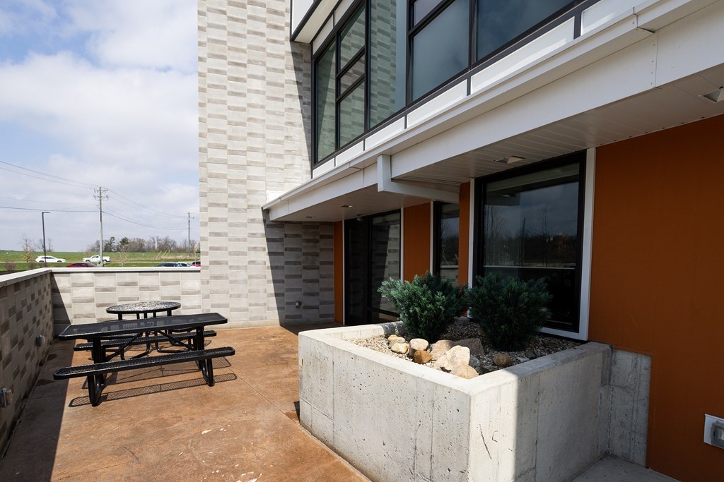 A patio with a table and a bench outside a house.