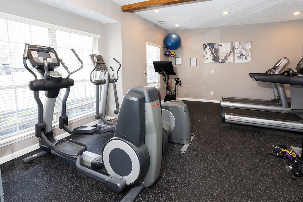 A gym with treadmills, elliptical machines, and other exercise equipment.