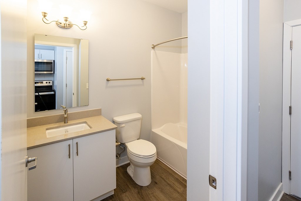 A white bathroom with a toilet, sink, and bathtub.