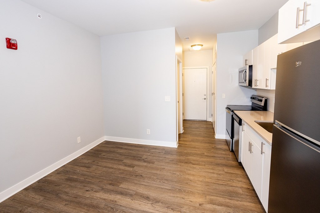 A kitchen with a refrigerator, microwave, and oven.