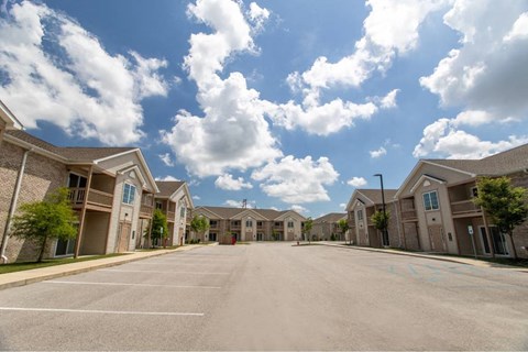 A row of houses with a parking lot in front.