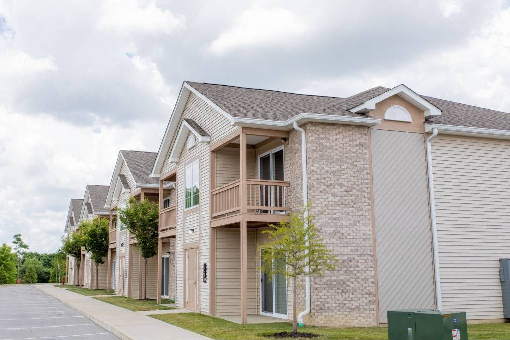 A row of houses with a tree in front of the first one.