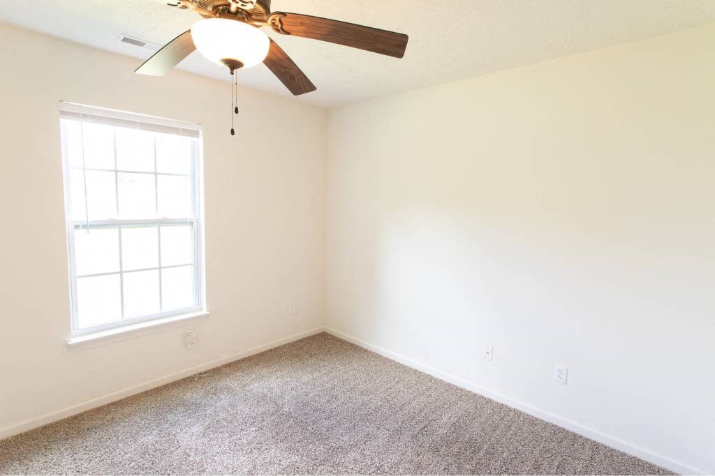 A room with a ceiling fan and a window.