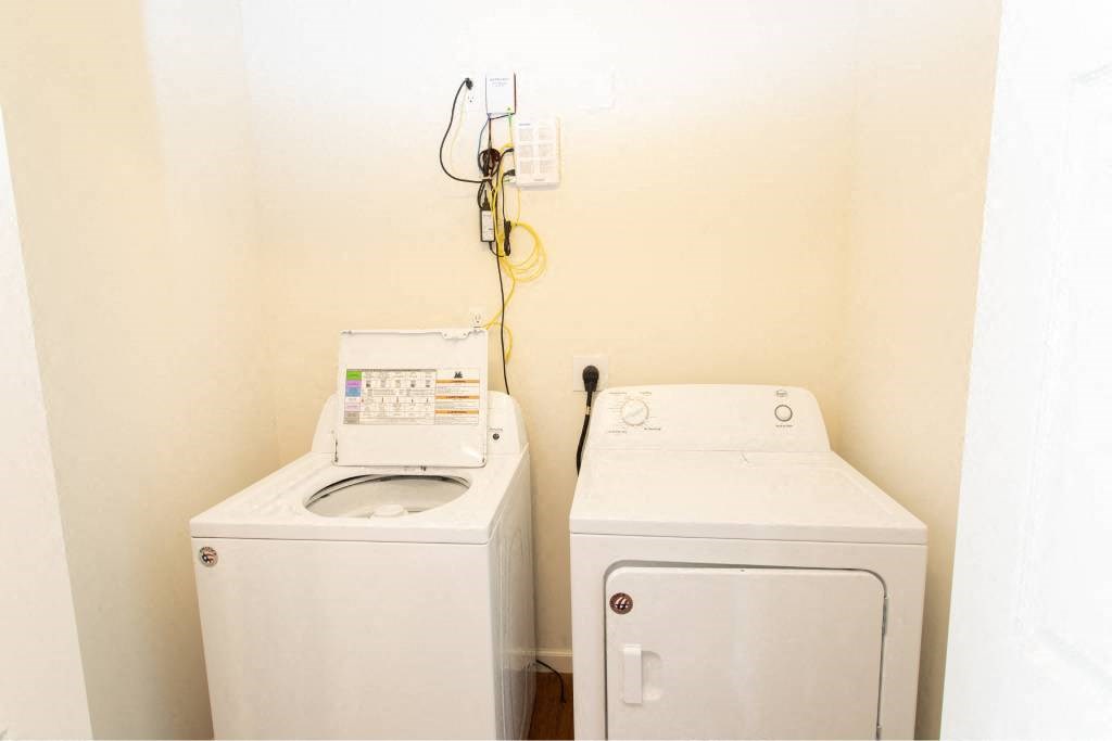 Two white washing machines in a small room.