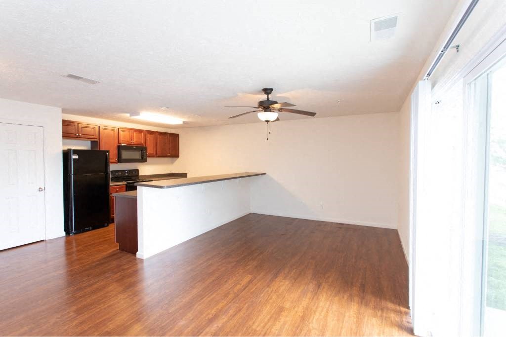A kitchen with a refrigerator, microwave, and oven.