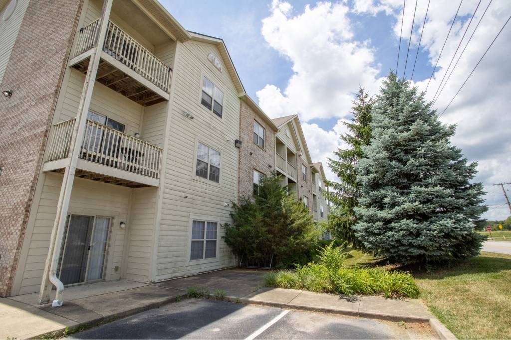A large apartment complex with a tree in front.
