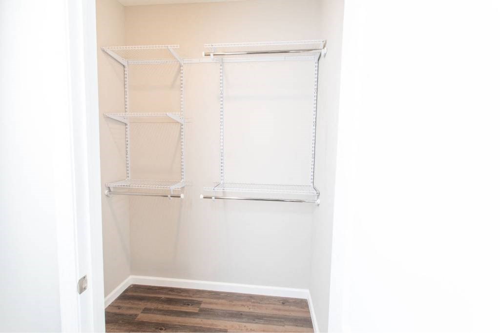 A white closet with shelves and a door.