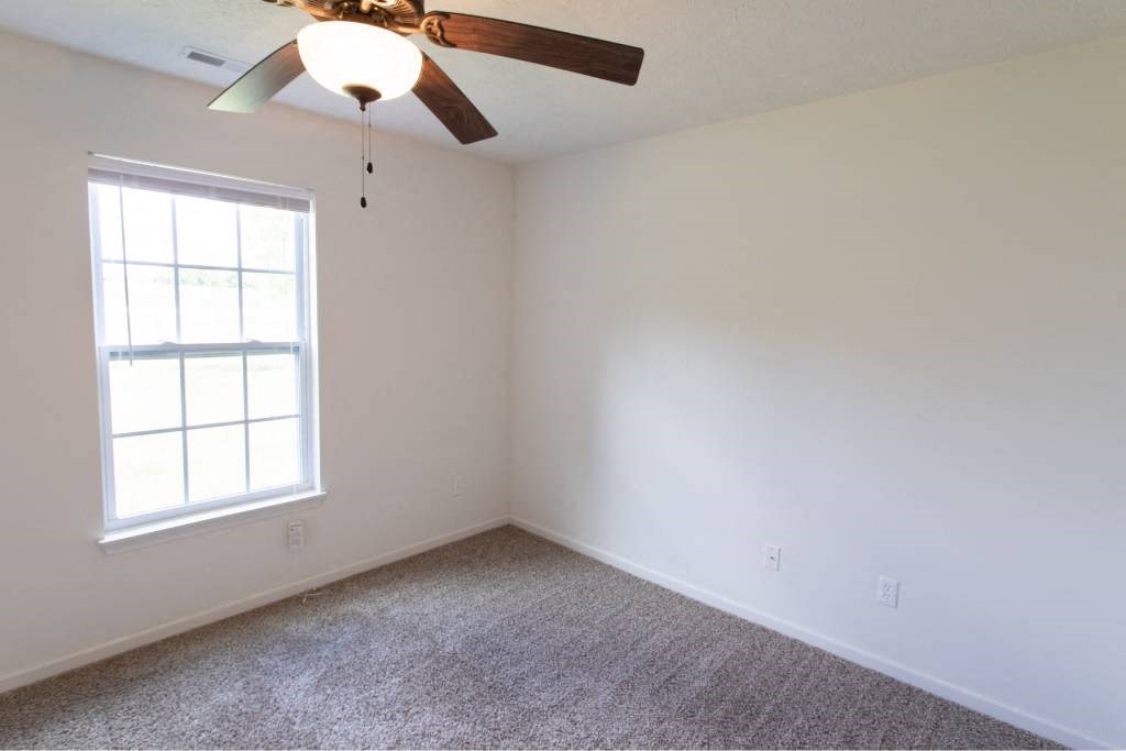 A room with a ceiling fan and a window.