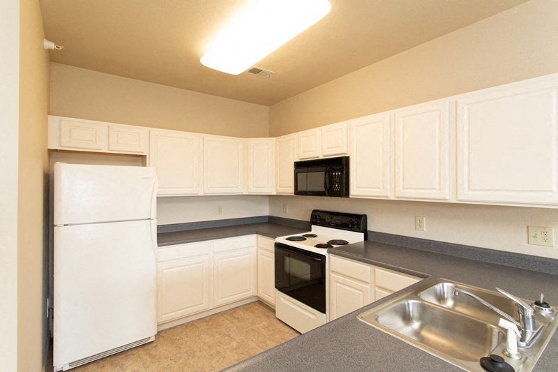 A kitchen with white appliances and cabinets.