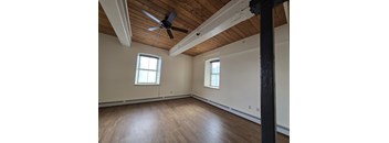 A room with wooden floors and a ceiling fan.