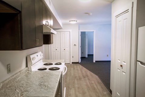 A kitchen with a stove top oven and a refrigerator.