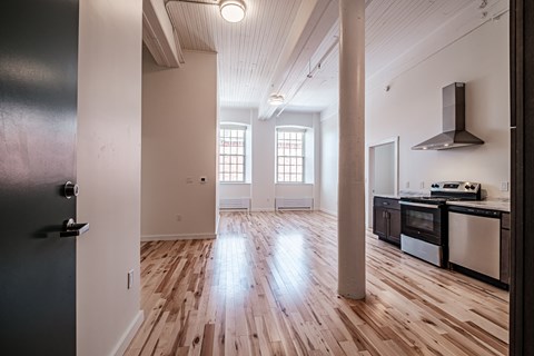 A kitchen with wooden floors and a stove top oven.