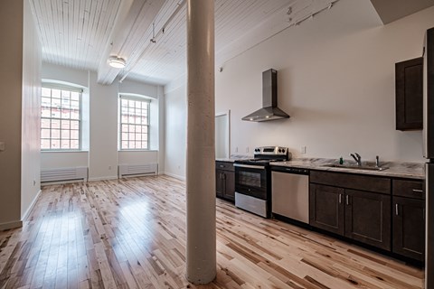 A kitchen with wooden floors and a stainless steel oven.
