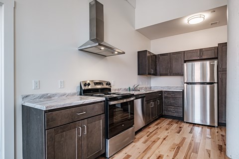 A kitchen with wooden floors and stainless steel appliances.
