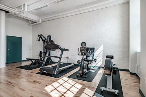 A gym with a treadmill and a stationary bike.