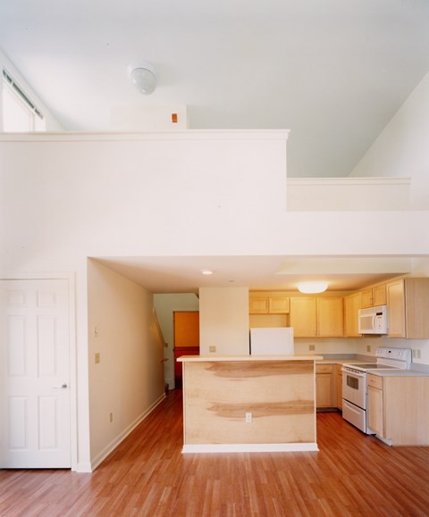 A kitchen with wooden floors and white walls.