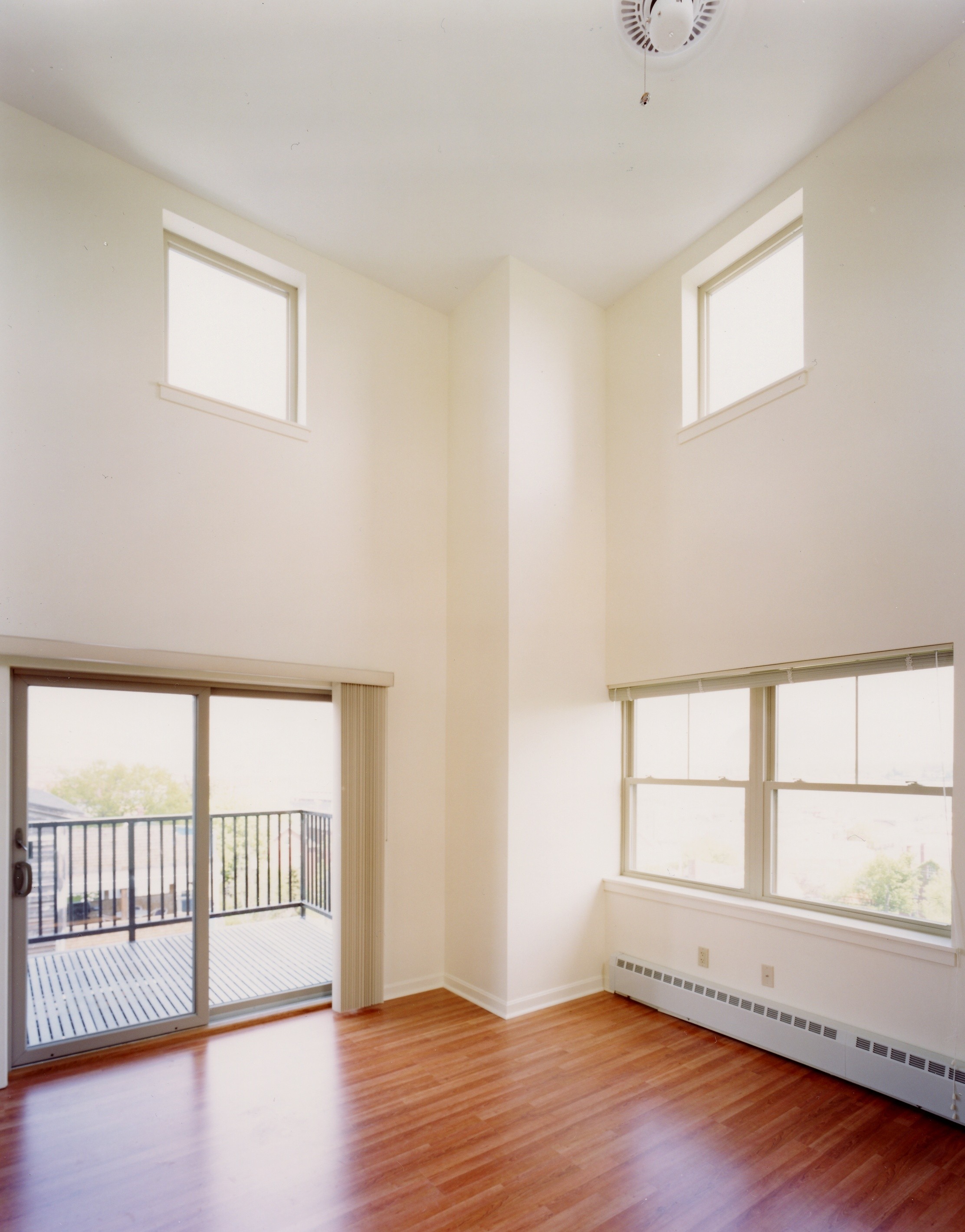 A room with a sliding glass door and hardwood floors.