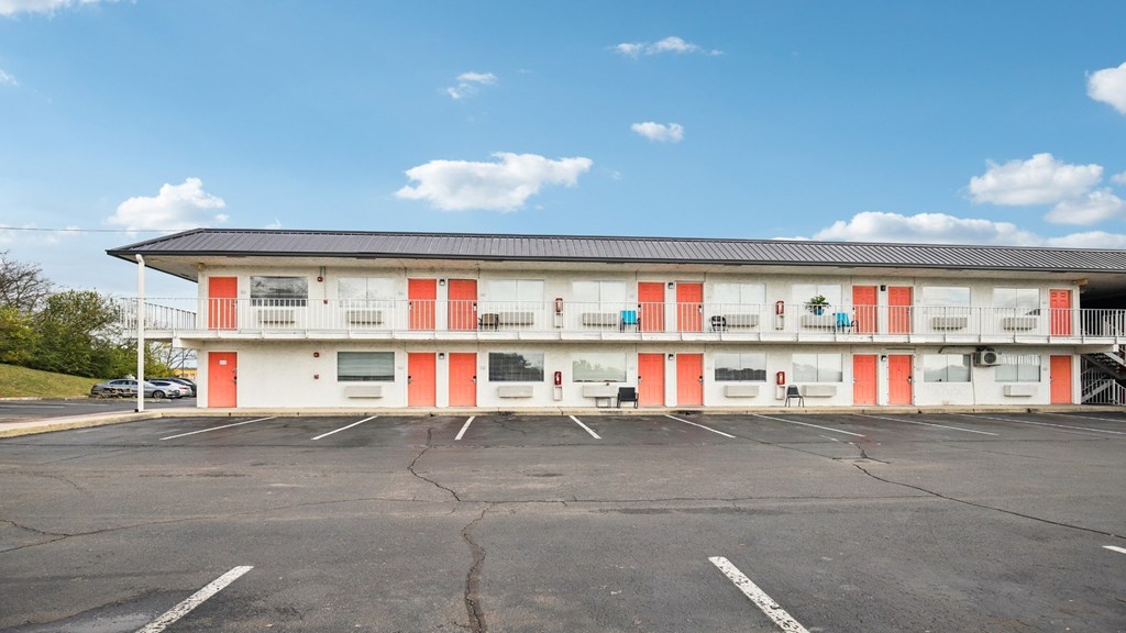 A parking lot in front of a building with red and white doors.