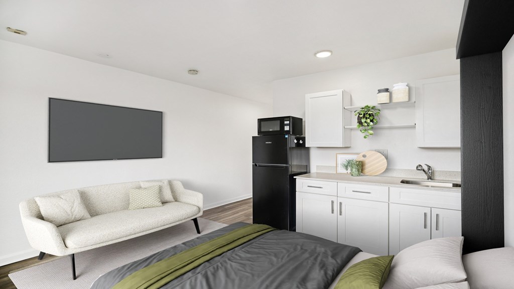 A modern living room with a white couch and a grey bed.