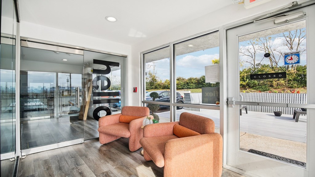 A modern living room with a glass door leading to a balcony.
