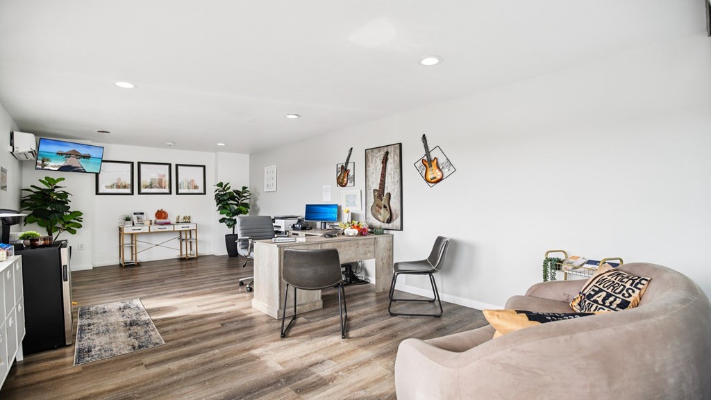 A modern living room with a grey couch and a TV mounted on the wall.