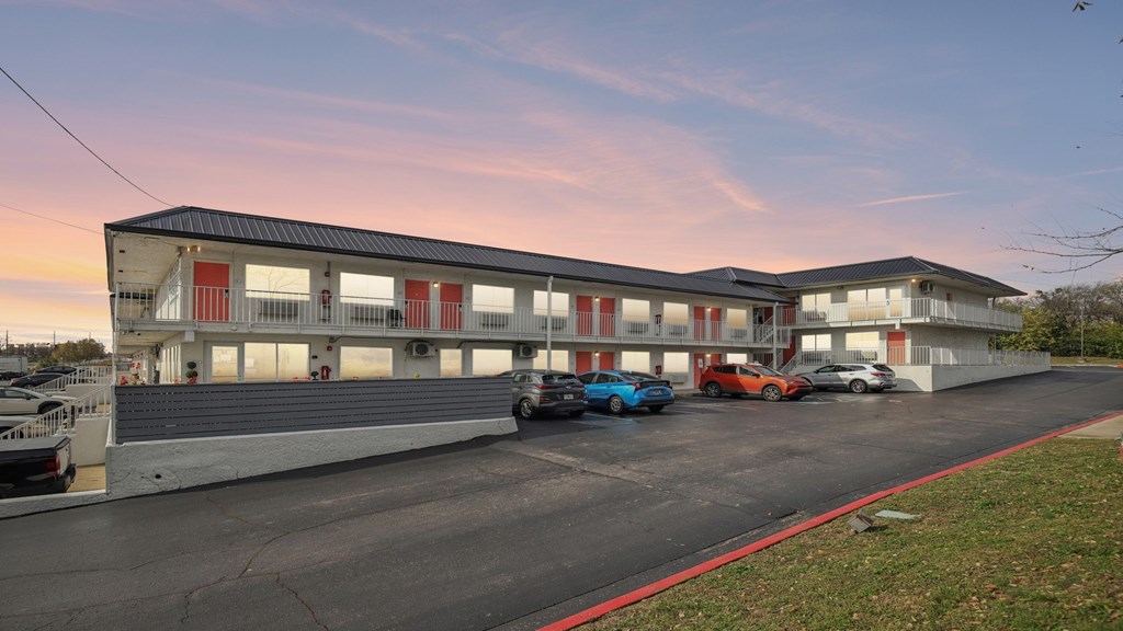 A parking lot with cars and a building in the background.
